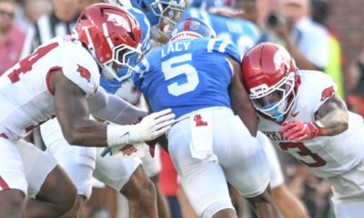 Arkansas Razorbacks defenders Stephen Dix and Larry Worth come together to down Ole Miss Rebels running back Kewan Lacy
