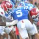 Arkansas Razorbacks defenders Stephen Dix and Larry Worth come together to down Ole Miss Rebels running back Kewan Lacy