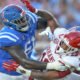 Arkansas Razorbacks linebacker Xavian Sorey takes a hard block from an Ole Miss Rebels offensive lineman